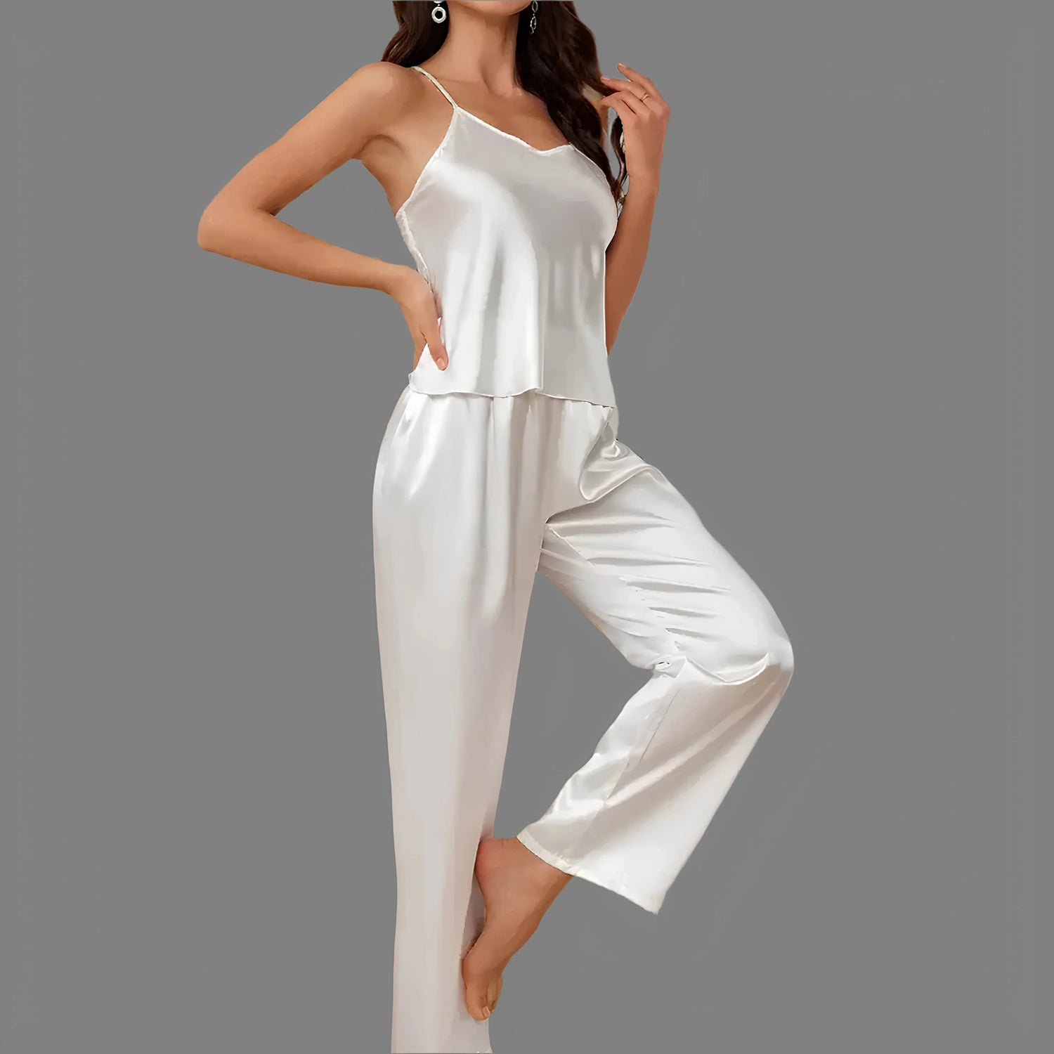 Woman wearing white satin pajama set against a gray background, showcasing elegant and cozy sleepwear for comfortable nights.