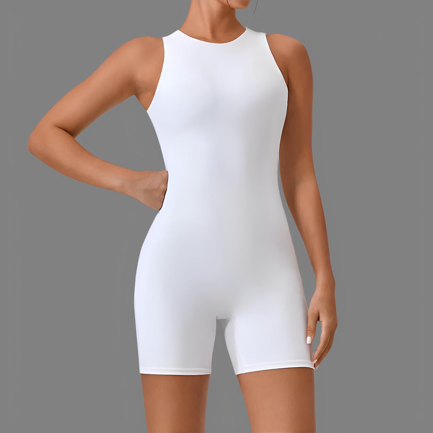 Woman wearing a sleeveless white bodysuit against a gray background, showcasing trendy and comfortable fashion.