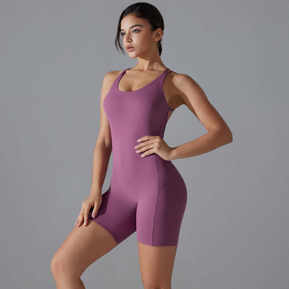 Woman wearing purple shaping one-piece shorts yoga, made from organic cotton. Features a relaxed fit and breathable material.