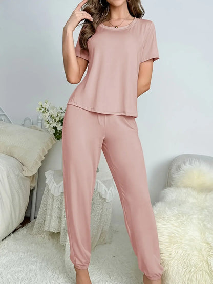 Woman wearing pink nightly comfort wear set made from organic cotton. Features relaxed fit and breathable material for comfort.