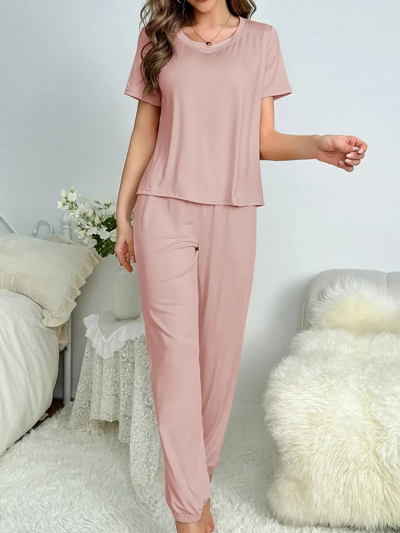 Woman wearing organic cotton nightly comfort wear. Relaxed fit and breathable material in light pink.