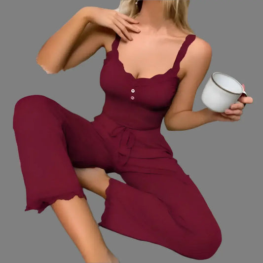 Women's casual pajama set in burgundy. Organic cotton, relaxed fit. Breathable material for comfort. Holds a cup, sitting casually.