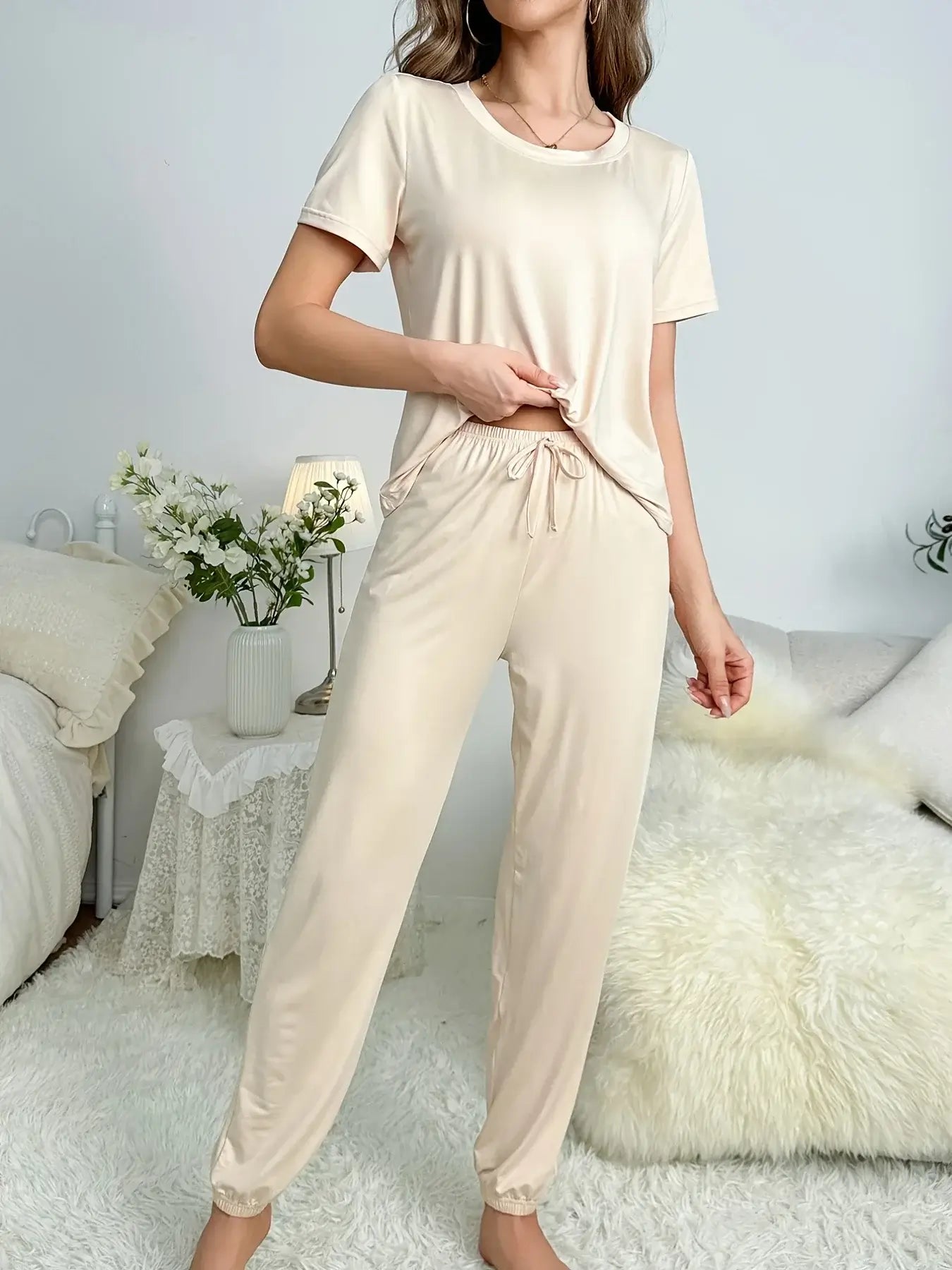 Organic cotton lounge set in cream color. Features relaxed fit and breathable material. Ideal for nightly comfort wear.